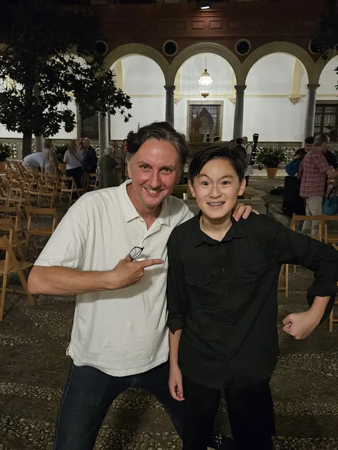 Justin Chen with a musician at the Granada Guitar Festival