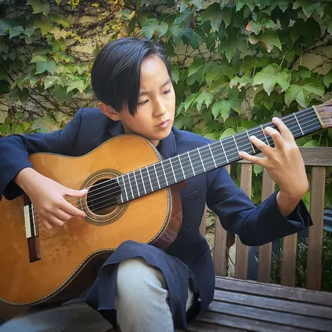 Justin Chen playing classical guitar outdoors