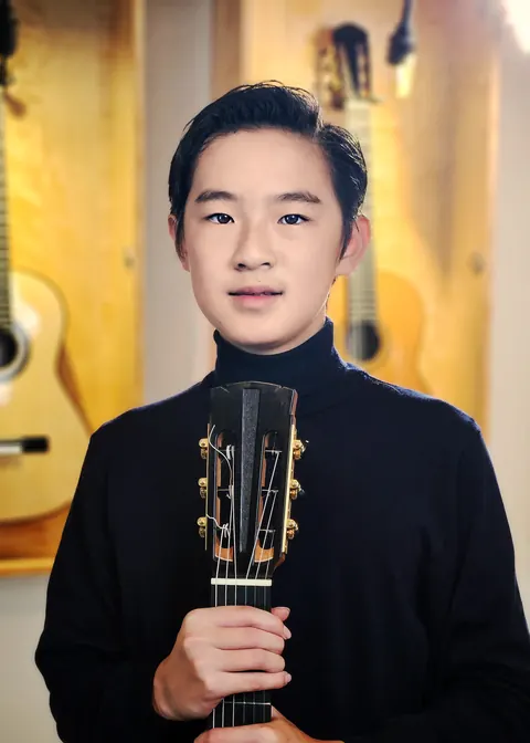 Justin Chen holding his classical guitar